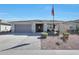 Inviting single-story home with a two-car garage, desert landscaping, and quaint front porch seating at 5121 N 181St Dr, Litchfield Park, AZ 85340