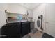 Functional laundry room with modern washer and dryer, utility sink, and storage shelves at 5121 N 181St Dr, Litchfield Park, AZ 85340