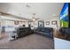 Open-concept living room with tile flooring, comfortable seating, and a view into the bright kitchen at 5121 N 181St Dr, Litchfield Park, AZ 85340