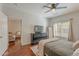 Cozy bedroom features a ceiling fan, dresser with television, wood floors and a window at 525 N Miller Rd # 122, Scottsdale, AZ 85257