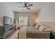 Inviting bedroom with wood floors, dresser with television, and a ceiling fan at 525 N Miller Rd # 122, Scottsdale, AZ 85257