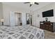 Spacious bedroom with tiled floors, closet doors, a TV, and a dresser for storage at 8176 S Pioneer Ct, Gold Canyon, AZ 85118