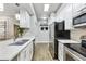 Galley kitchen with stainless steel appliances, white cabinetry, and stone countertops at 8653 E Royal Palm Rd # 1033, Scottsdale, AZ 85258