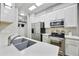 Well-lit kitchen featuring stainless steel appliances, white cabinetry, and stone countertops at 8653 E Royal Palm Rd # 1033, Scottsdale, AZ 85258