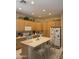 Well-lit kitchen features an island with bar seating, oak cabinets, and modern appliances at 901 W Oriole Way, Chandler, AZ 85286