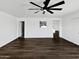 A large, open living room with modern ceiling fan and wood-look floors at 909 W Danbury Rd, Phoenix, AZ 85023