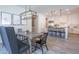 Open-concept dining area with rustic table, modern light fixture, and views into kitchen at 9266 E Desert Village Dr, Scottsdale, AZ 85255