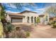 Inviting single-story stucco home showcasing desert landscaping, a tiled roof and a charming arched entry at 9266 E Desert Village Dr, Scottsdale, AZ 85255