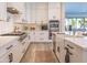 Modern kitchen with white cabinetry, stainless steel appliances, and a stylish herringbone backsplash at 9266 E Desert Village Dr, Scottsdale, AZ 85255