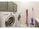 Functional laundry room with modern washer and dryer, storage cabinets, and stylish flooring at 9266 E Desert Village Dr, Scottsdale, AZ 85255