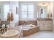 Large soaking tub framed by custom tile work, set in a bathroom with large mirrors and windows at 9266 E Desert Village Dr, Scottsdale, AZ 85255