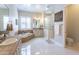 Bright main bathroom with a soaking tub, white marble floors, and a separate glass block shower at 9266 E Desert Village Dr, Scottsdale, AZ 85255