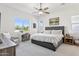 Bright bedroom with a large window, desk, ceiling fan, and tufted headboard at 942 E Paseo Way, Phoenix, AZ 85042