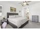 Bright bedroom showcasing a tufted headboard, ceiling fan, and an adjacent bathroom at 942 E Paseo Way, Phoenix, AZ 85042