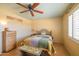 Comfortable bedroom with a colorful quilt and window with white shutters at 9513 W Cottonwood Dr, Sun City, AZ 85373