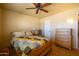 Comfortable bedroom includes neutral walls, ceiling fan, dresser, and chair at 9513 W Cottonwood Dr, Sun City, AZ 85373