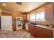 Well-lit kitchen featuring wood cabinets, white appliances, and a window view at 9513 W Cottonwood Dr, Sun City, AZ 85373