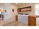 Laundry room with modern washer and dryer, shelving, and tile flooring at 9513 W Cottonwood Dr, Sun City, AZ 85373