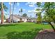 Expansive backyard featuring a lush lawn, sparkling pool, and a variety of palm trees at 10052 N 77Th St, Scottsdale, AZ 85258