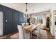 This dining room has a blue accent wall, light wood table, and modern light fixtures at 10052 N 77Th St, Scottsdale, AZ 85258