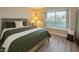 Cozy bedroom with a large window, stylish decor, wood-look flooring, and comfortable furnishings at 1016 E Utopia Rd, Phoenix, AZ 85024