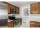 Modern kitchen with updated stainless appliances and wood cabinetry at 1016 E Utopia Rd, Phoenix, AZ 85024