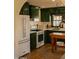Well-lit kitchen featuring green cabinetry, stainless steel appliances, and a white tile backsplash at 102 W Washington Ave, Gilbert, AZ 85233
