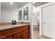 Bathroom featuring a modern sink, wood cabinet, and storage, all conveniently located next to the bedroom and hallway at 10610 S 48Th St # 2001, Phoenix, AZ 85044