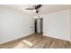 This bedroom features wood floors, a ceiling fan, a closet and an adjacent doorway at 10610 S 48Th St # 2001, Phoenix, AZ 85044