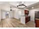 Open-concept living room boasts wood floors, fan, and sliding doors to a balcony, flowing to an updated kitchen with a breakfast bar at 10610 S 48Th St # 2001, Phoenix, AZ 85044