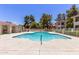 Community pool featuring crystal clear water with a clear blue sky and surrounded by mature shade trees at 10610 S 48Th St # 2001, Phoenix, AZ 85044