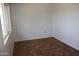 A vacant bedroom with brown tile flooring and good sunlight from a large window at 10621 N 115Th Ave, Youngtown, AZ 85363