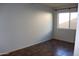 A vacant bedroom with brown tile flooring and good sunlight from a large window at 10621 N 115Th Ave, Youngtown, AZ 85363