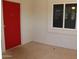 Close up of the covered entry with bright red door and window at 10621 N 115Th Ave, Youngtown, AZ 85363