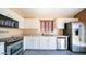 Modern kitchen with stainless steel appliances, white cabinetry, and gray countertops at 10851 E Clovis Ave, Mesa, AZ 85208
