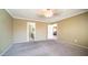 Large primary bedroom with neutral walls, carpet, and multiple doorways at 10851 E Clovis Ave, Mesa, AZ 85208