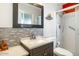 Nicely remodeled bathroom features stone tile accents, a modern vanity, and a glass-enclosed shower at 10922 W Peoria Ave, Sun City, AZ 85351