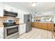 Open-concept kitchen with stainless steel appliances, tile flooring, and warm wood accents at 10922 W Peoria Ave, Sun City, AZ 85351