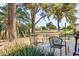 Relaxing patio area with chairs and tables surrounded by lush greenery and mature trees at 10922 W Peoria Ave, Sun City, AZ 85351