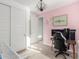 Bedroom with a desk, black chair, pink wall, white trim and a sliding door closet at 12344 E Soloman Rd, Gold Canyon, AZ 85118