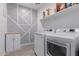 Laundry room with gray and white patterned wallpaper, wooden crates and a front loading washer and dryer at 12344 E Soloman Rd, Gold Canyon, AZ 85118