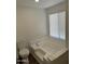 Bathroom with a white toilet and a built-in bathtub area next to a window with blinds at 12814 N 19Th Pl # 19, Phoenix, AZ 85022