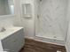 Bathroom featuring a walk-in shower with elegant marble-style tiling, and a modern vanity at 12814 N 19Th Pl # 19, Phoenix, AZ 85022