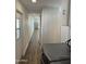 Long hallway leading to the kitchen, featuring tile floors and a laundry area with a modern washer at 12814 N 19Th Pl # 19, Phoenix, AZ 85022