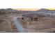 High angle view of single Gathering home, gravel driveway, covered patio and mountain backdrop at 12942 S 218Th Ave, Buckeye, AZ 85326