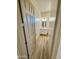 Hallway view to the bathroom features a white vanity with marble countertop, and modern lighting fixture at 12942 S 218Th Ave, Buckeye, AZ 85326