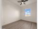Bright bedroom with wood flooring, modern ceiling fan, and ample natural light from a spacious window at 12942 S 218Th Ave, Buckeye, AZ 85326