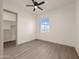 Bright bedroom featuring modern flooring, large windows, and an open closet at 12942 S 218Th Ave, Buckeye, AZ 85326