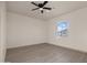 A bright bedroom with light-colored walls, neutral floors, a ceiling fan, and a window with a scenic outdoor view at 12942 S 218Th Ave, Buckeye, AZ 85326