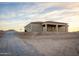 Home with tile roof and covered patio, set against a backdrop of a cloudy sunset sky at 12942 S 218Th Ave, Buckeye, AZ 85326